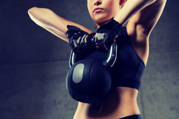 close up of woman with kettlebell in gym