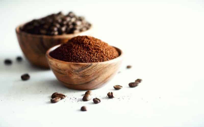 Ingredients for making caffeine drink - coffee beans, ground and instant coffee on light concrete