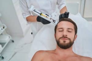 Man being treated for hair loss in a beauty clinic